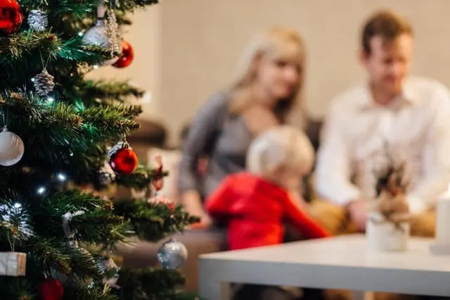 saving money for Christmas Middle Class Dad Dad, Mom and child around a Christmas tree