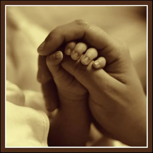 life insurance tips and advice Middle Class Dad sepia colored picture of a young hand being held by an older hand
