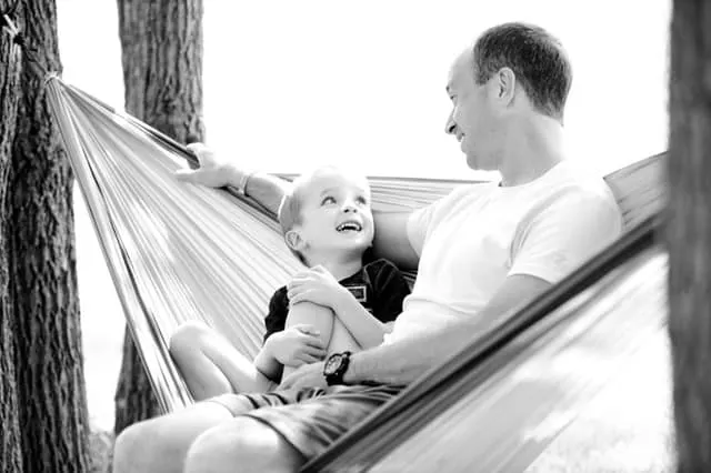 qualities of a good father dad in hammock with kid middle class dad