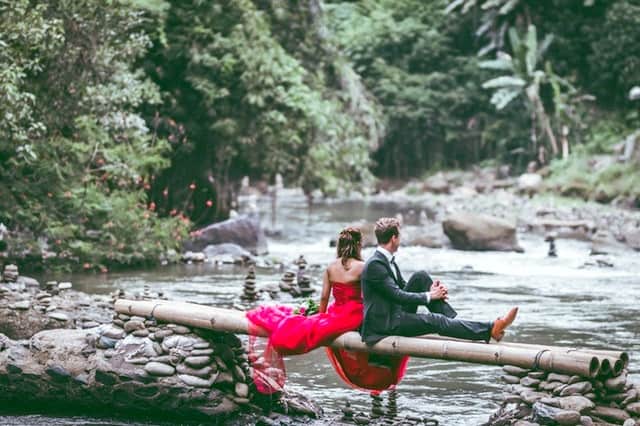 ways to help your relationship grow man and woman sitting on a log laying over a river in the woods middle class dad