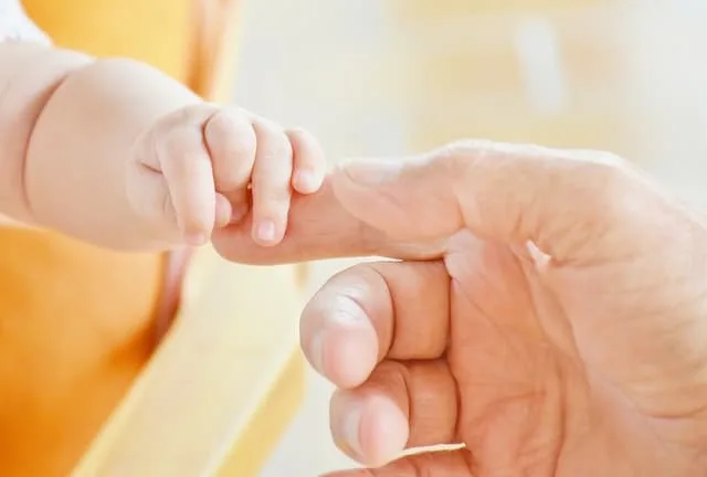 expectant father anxiety Middle Class Dad adult man's hand with pointer finger extended with a baby's hand grabbing the finger