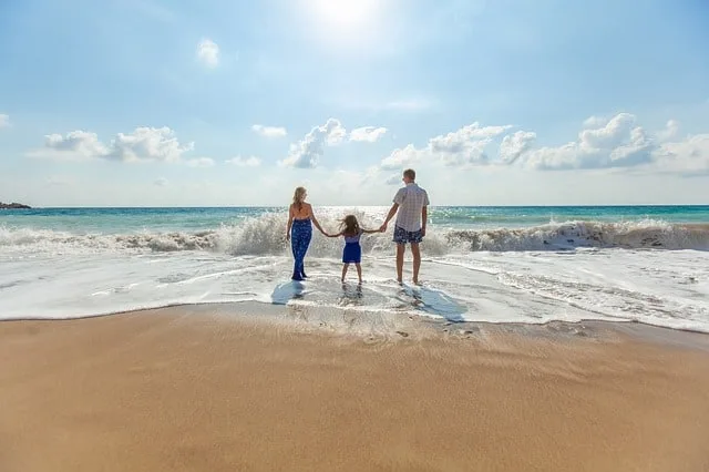 summer family vacation ideas mom, dad and child on a beach Middle Class Dad