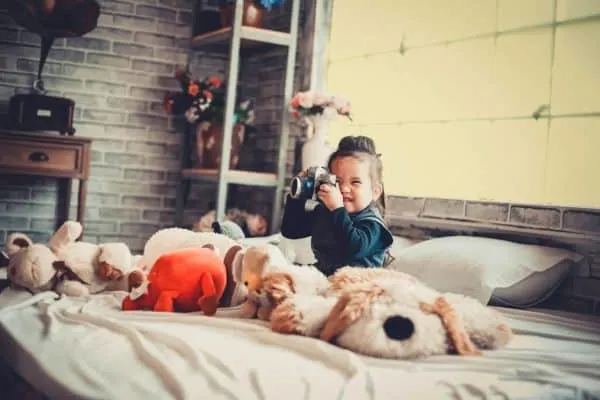 girl sitting in bedroom surrounded by stuffed animals middle class dad