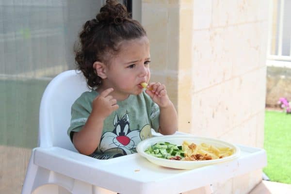 how to overcome picky eating overhead shot of a young child eating in a high chair Middle Class Dad