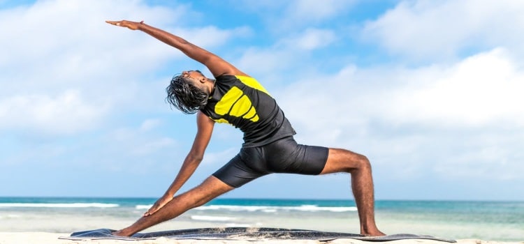 Middle Class Dad yogic breathing benefits man practicing yoga in a black and yellow outfit on the beach